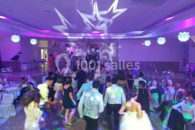 Parking extérieur rempli de voitures, avec un homme debout près d'une Audi noire sous un ciel dégagé.