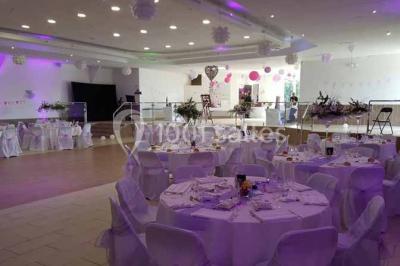 Parking extérieur rempli de voitures, avec un homme debout près d'une Audi noire sous un ciel dégagé.