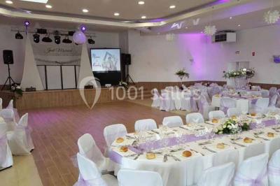 Parking extérieur rempli de voitures, avec un homme debout près d'une Audi noire sous un ciel dégagé.