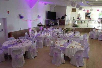 Parking extérieur rempli de voitures, avec un homme debout près d'une Audi noire sous un ciel dégagé.