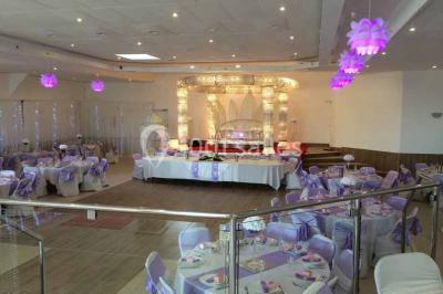 Parking extérieur rempli de voitures, avec un homme debout près d'une Audi noire sous un ciel dégagé.