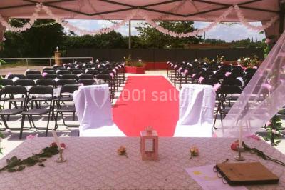 Parking extérieur rempli de voitures, avec un homme debout près d'une Audi noire sous un ciel dégagé.