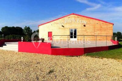 Parking extérieur rempli de voitures, avec un homme debout près d'une Audi noire sous un ciel dégagé.