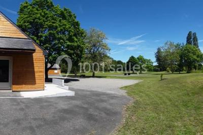 Maisons en rangée avec façades en bois, entourées d'arbres et d'espaces verts, sous un ciel dégagé.
