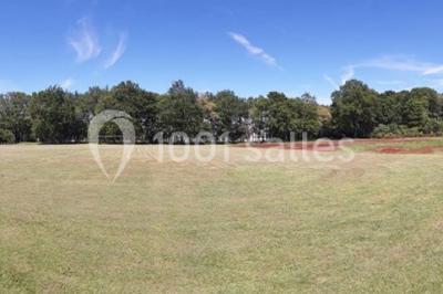 Maisons en rangée avec façades en bois, entourées d'arbres et d'espaces verts, sous un ciel dégagé.