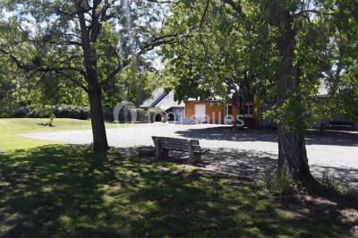 Maisons en rangée avec façades en bois, entourées d'arbres et d'espaces verts, sous un ciel dégagé.