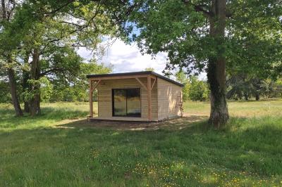 Maisons en rangée avec façades en bois, entourées d'arbres et d'espaces verts, sous un ciel dégagé.