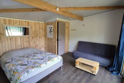 Maisons en rangée avec façades en bois, entourées d'arbres et d'espaces verts, sous un ciel dégagé.