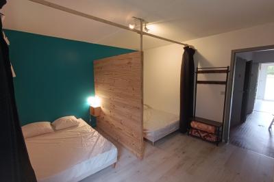 Maisons en rangée avec façades en bois, entourées d'arbres et d'espaces verts, sous un ciel dégagé.