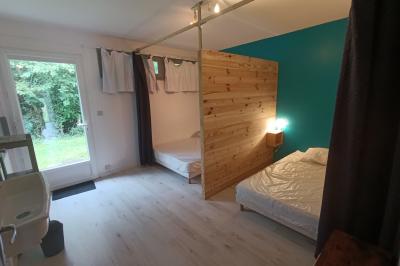 Maisons en rangée avec façades en bois, entourées d'arbres et d'espaces verts, sous un ciel dégagé.