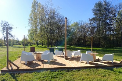 Maisons en rangée avec façades en bois, entourées d'arbres et d'espaces verts, sous un ciel dégagé.