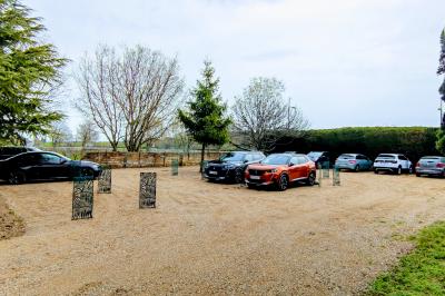 Panneau en métal rouillé indiquant ’Les Coquilloux’, avec des informations sur des gîtes, réceptions, piscine et un numéro…