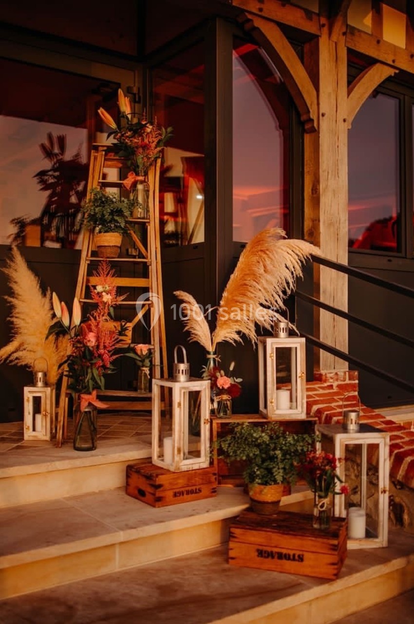 Décoration extérieure avec lanternes, fleurs et herbes de la pampa sur des marches au coucher du soleil.