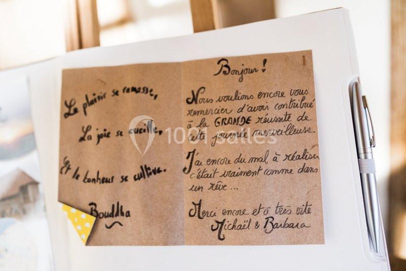 Carte manuscrite avec un message de remerciement et une citation de Bouddha, posée sur un support blanc avec un stylo.