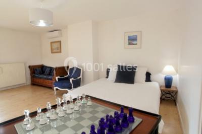 Deux lits simples avec housses rouges à pois blancs dans une chambre lumineuse décorée de touches rouges et blanches.