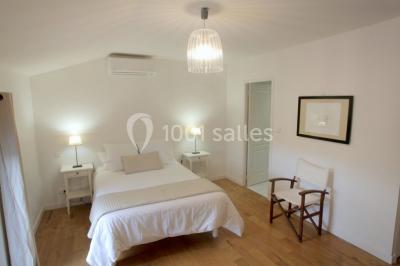 Deux lits simples avec housses rouges à pois blancs dans une chambre lumineuse décorée de touches rouges et blanches.