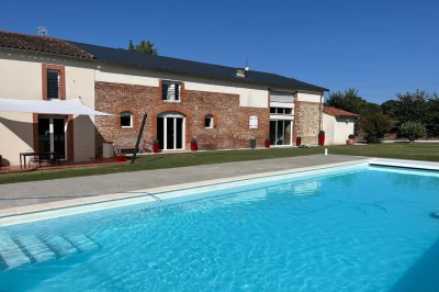 Deux lits simples avec housses rouges à pois blancs dans une chambre lumineuse décorée de touches rouges et blanches.
