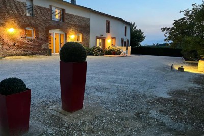 Deux lits simples avec housses rouges à pois blancs dans une chambre lumineuse décorée de touches rouges et blanches.