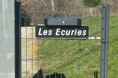 Deux lits simples avec housses rouges à pois blancs dans une chambre lumineuse décorée de touches rouges et blanches.