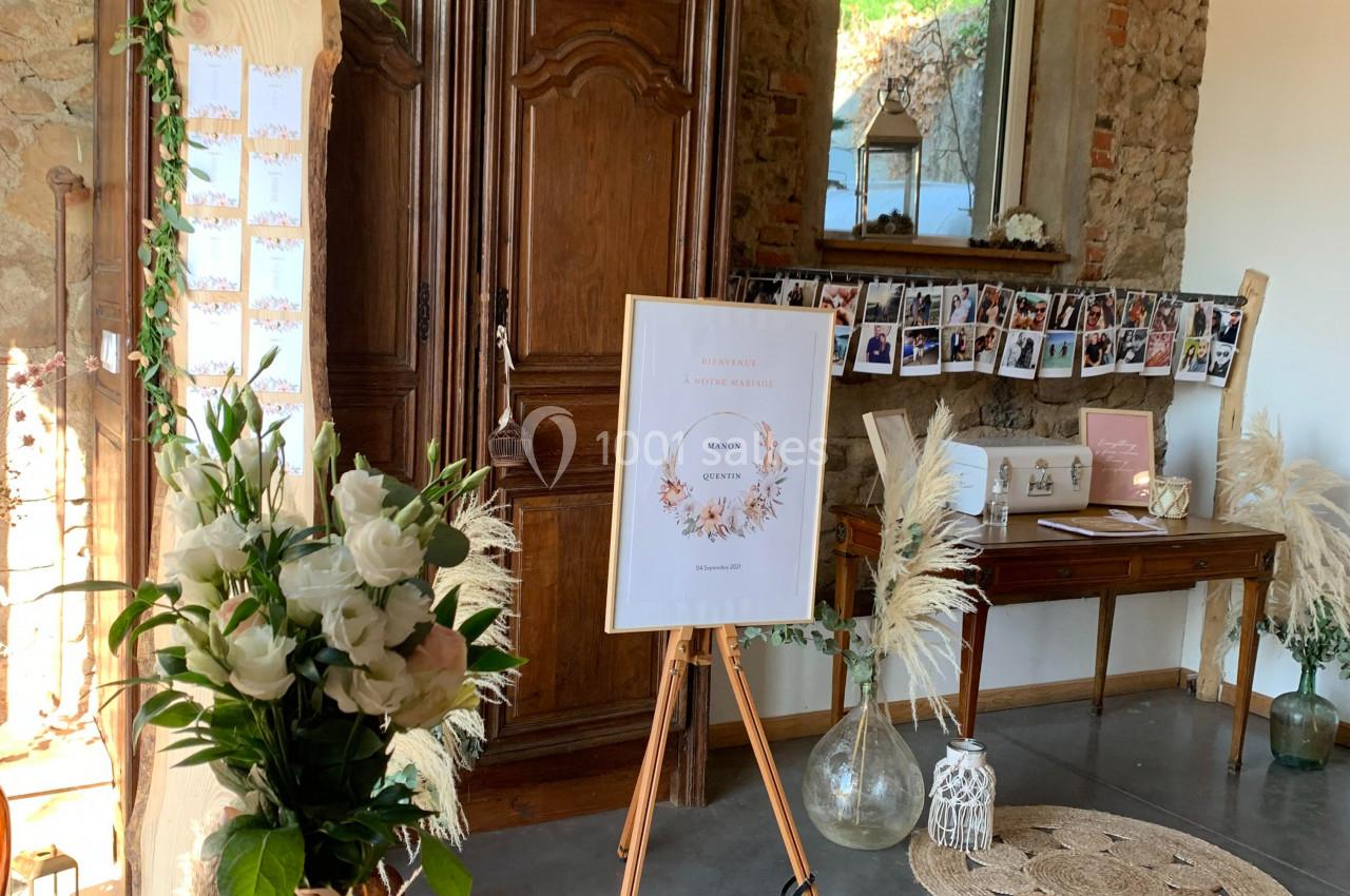 Décoration intérieure avec fleurs blanches, armoire en bois, photos suspendues et panneau sur chevalet dans une pièce en…