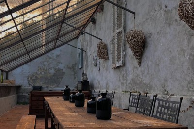 Cour pavée d'un bâtiment en pierre éclairé par des lumières extérieures, entouré d'arbres et de bâtiments annexes, de nuit.