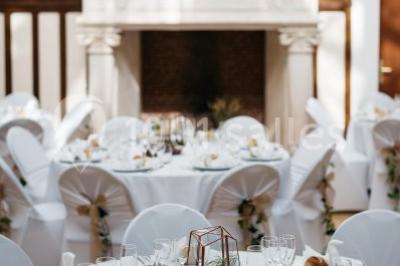 Pelouse verdoyante bordée d'arbres hauts sous un ciel bleu clair, avec une petite structure en briques à gauche.