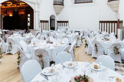 Pelouse verdoyante bordée d'arbres hauts sous un ciel bleu clair, avec une petite structure en briques à gauche.