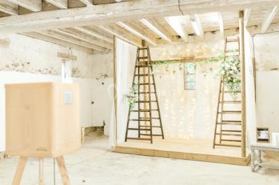 Cuisine professionnelle avec équipements en inox, plans de travail, éviers, chariots et plafond avec poutres apparentes.