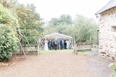 Cuisine professionnelle avec équipements en inox, plans de travail, éviers, chariots et plafond avec poutres apparentes.