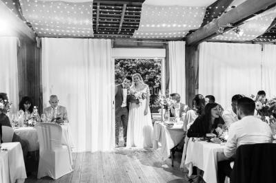 Cuisine professionnelle avec équipements en inox, plans de travail, éviers, chariots et plafond avec poutres apparentes.