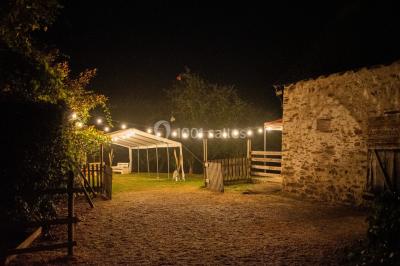 Cuisine professionnelle avec équipements en inox, plans de travail, éviers, chariots et plafond avec poutres apparentes.
