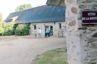 Cuisine professionnelle avec équipements en inox, plans de travail, éviers, chariots et plafond avec poutres apparentes.