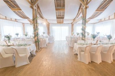 Cuisine professionnelle avec équipements en inox, plans de travail, éviers, chariots et plafond avec poutres apparentes.