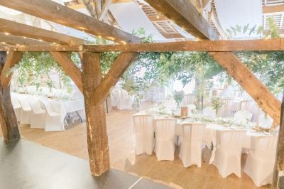 Cuisine professionnelle avec équipements en inox, plans de travail, éviers, chariots et plafond avec poutres apparentes.