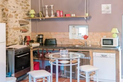 Salle de réception avec tables dressées, nappes noires, chaises blanches et parquet en bois clair.
