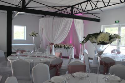 Salle de bain avec lavabo, miroir, urinoir et carrelage blanc et bleu, éclairée par une lumière naturelle.