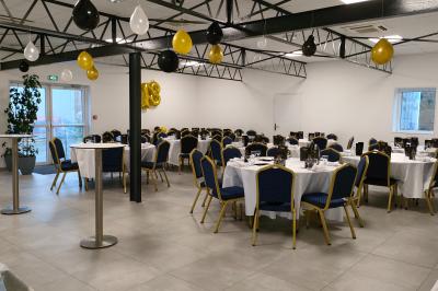Salle de bain avec lavabo, miroir, urinoir et carrelage blanc et bleu, éclairée par une lumière naturelle.