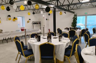 Salle de bain avec lavabo, miroir, urinoir et carrelage blanc et bleu, éclairée par une lumière naturelle.