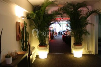 Plusieurs motos stationnées dans un parking entouré d'arbres, avec un véhicule utilitaire en arrière-plan.