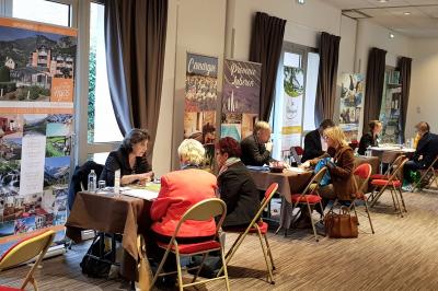 Plusieurs motos stationnées dans un parking entouré d'arbres, avec un véhicule utilitaire en arrière-plan.