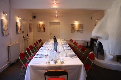 Plusieurs motos stationnées dans un parking entouré d'arbres, avec un véhicule utilitaire en arrière-plan.