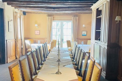 Chambre avec lit double, canapé, table basse et poutres apparentes, décorée de papier peint à motifs.