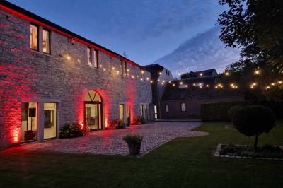 Vue aérienne d'un complexe avec plusieurs bâtiments, un jardin central, un parking et des zones identifiées par des noms.