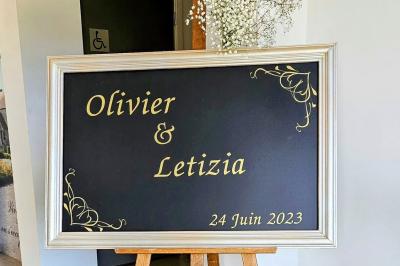 Vue aérienne d'un complexe avec plusieurs bâtiments, un jardin central, un parking et des zones identifiées par des noms.