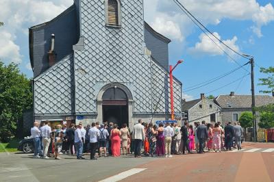 Vue aérienne d'un complexe avec plusieurs bâtiments, un jardin central, un parking et des zones identifiées par des noms.