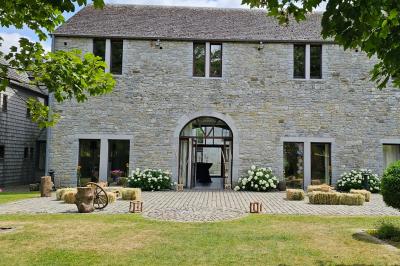 Vue aérienne d'un complexe avec plusieurs bâtiments, un jardin central, un parking et des zones identifiées par des noms.
