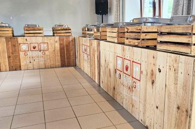 Vue aérienne d'un complexe avec plusieurs bâtiments, un jardin central, un parking et des zones identifiées par des noms.