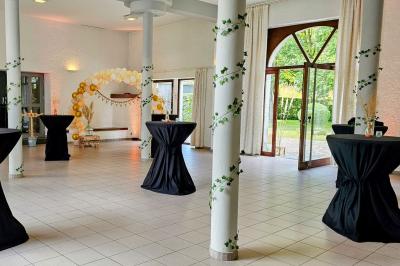 Vue aérienne d'un complexe avec plusieurs bâtiments, un jardin central, un parking et des zones identifiées par des noms.