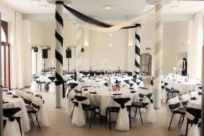 Vue aérienne d'un complexe avec plusieurs bâtiments, un jardin central, un parking et des zones identifiées par des noms.