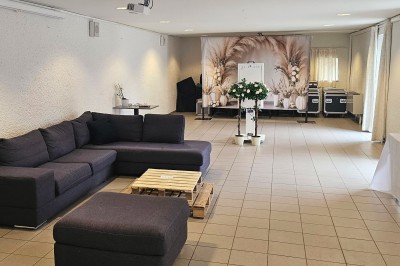 Vue aérienne d'un complexe avec plusieurs bâtiments, un jardin central, un parking et des zones identifiées par des noms.